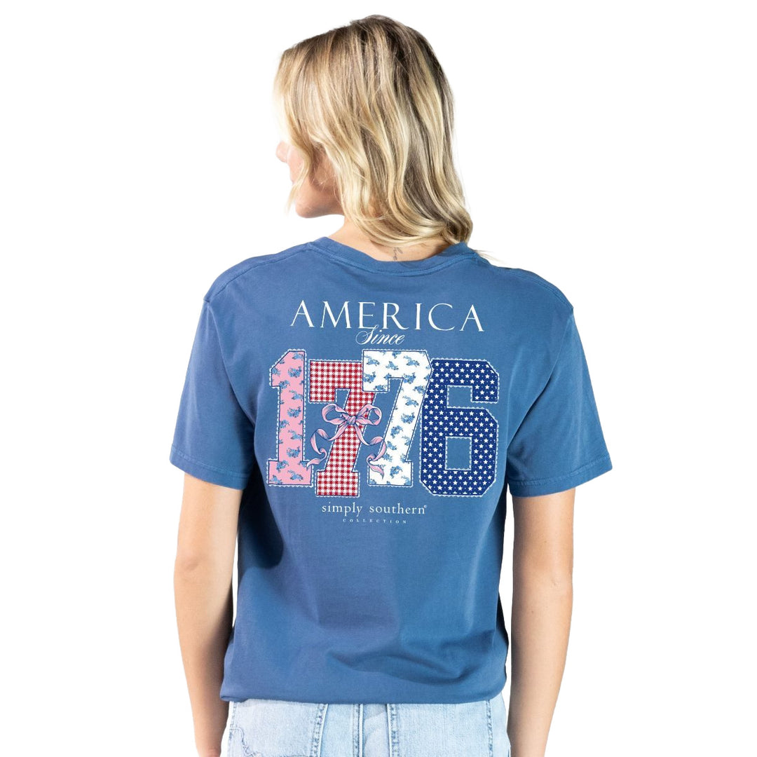 Woman wearing a blue t-shirt with 'America Since 1776' Simply Southern design on the back.