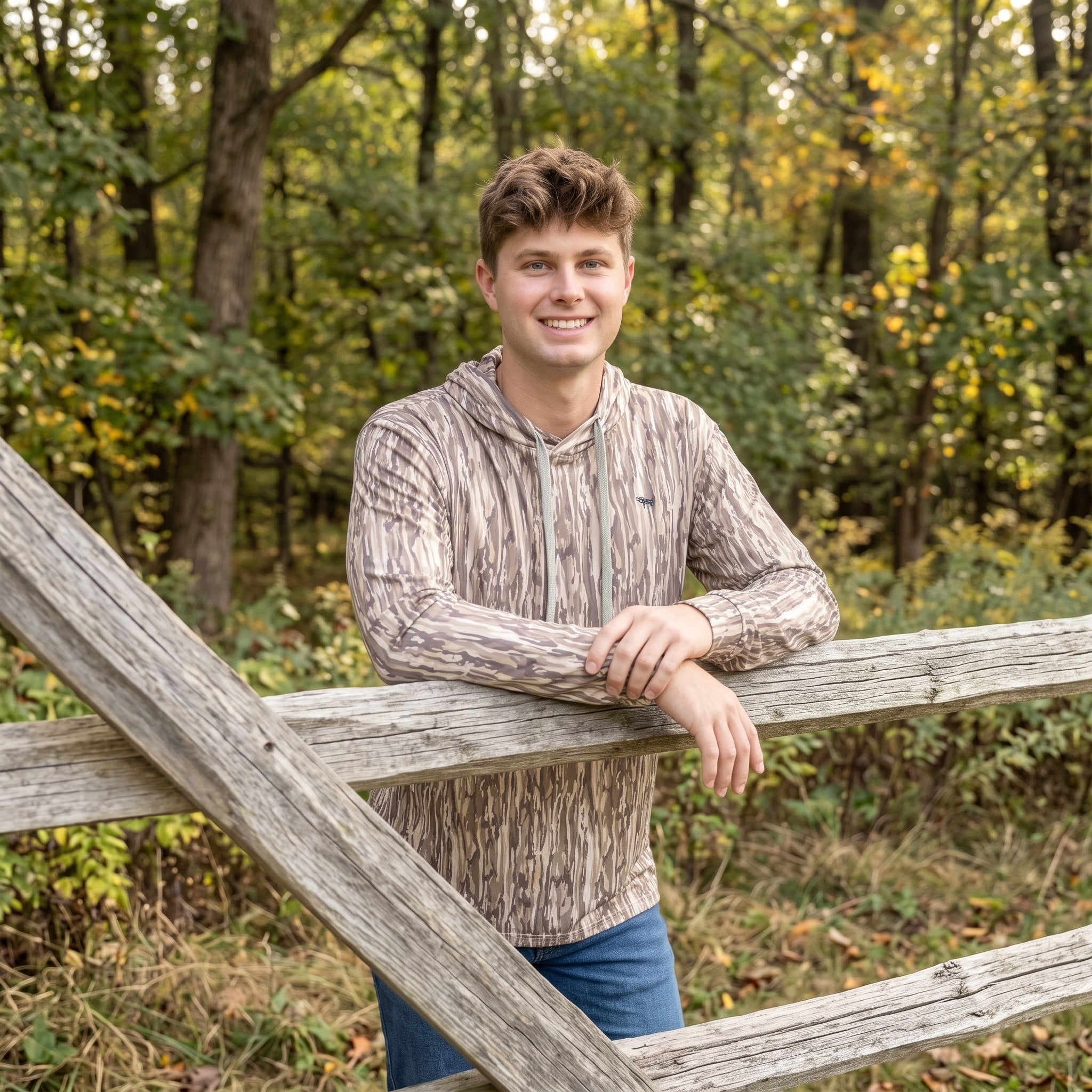 Man wearing a brown camouflage hoodie and jeans outdoors in fall for the Serendipity Gifts men’s clothing collection.