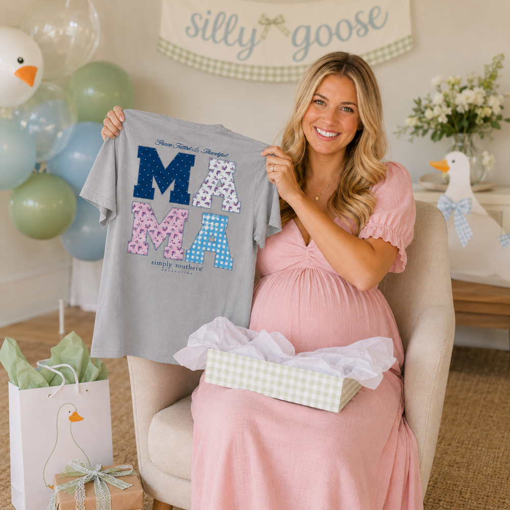 Pregnant woman holding gray Simply Southern Mama graphic tee at baby shower 