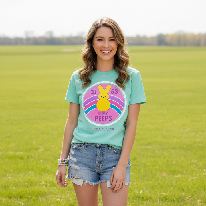 Woman wearing Simply Southern Peeps Easter t-shirt in mint green with light denim shorts outdoors